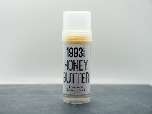 2oz honey butter moisture stick, plastic twist tube, with a while lable with black lettering