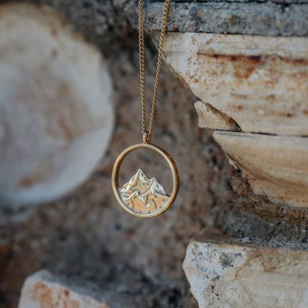 Breaking point necklace hanging from a stone backdrop