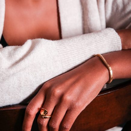 Love open ring in gold on model hand paired with gold horizon set 